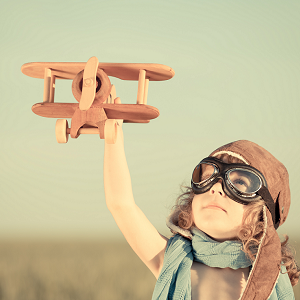 young girl with a wooden aircraft toyy