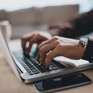 Hands typing on laptop computer