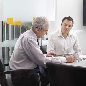 two men discussing papers