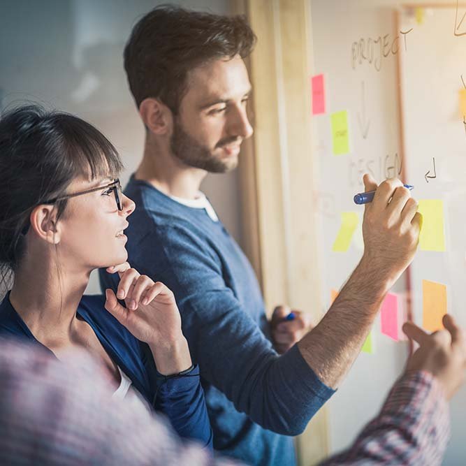 man writing on board