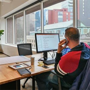 man on cellphone in front of computer