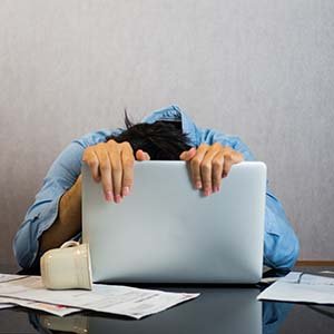 man stressed out on a laptop