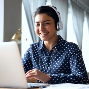 girl with headphones on a computer